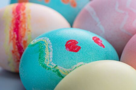 Colorful Easter eggs dyed by colored water isolated on a pale blue background, design concept of...