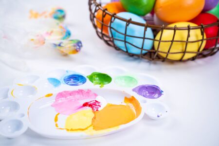 Design concept - Preparing for Easter celebration, painting Easter eggs with colorful Acrylic pigment color dyestuff in palette, close up, lifestyle.の写真素材