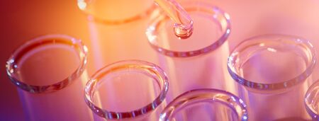 Test tube row. Concept of medical or science laboratory, liquid drop droplet with dropper in blue tone background, close up, micro photography picture.の写真素材