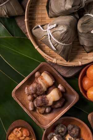 Rice dumpling, zongzi - Traditional Chinese food on green leaf background of Dragon Boat Festival, Duanwu Festival, top view, flat lay design concept.の写真素材