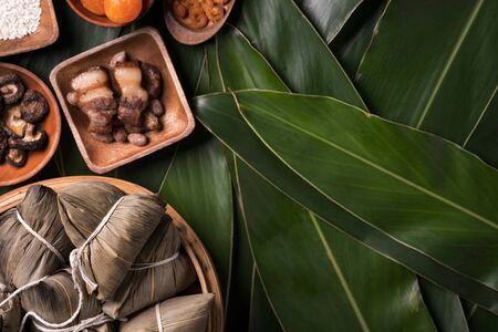 Rice dumpling, zongzi - Traditional Chinese food on green leaf background of Dragon Boat Festival, Duanwu Festival, top view, flat lay design concept.の写真素材