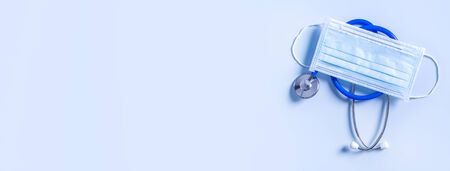 Blue mask - medical equipment with stethoscope, concept of world disease pandemic infection and prevention, top view, flat lay, overhead designの写真素材