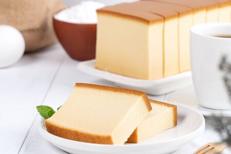 Castella (kasutera) - Beautiful delicious Japanese sliced sponge cake food on white plate over rustic white wooden table, close up, copy space design concept.の写真素材