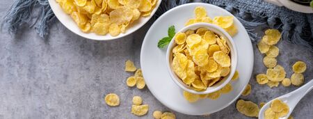 Corn flakes bowl sweets on gray cement background, top view flat lay layout design, fresh and...