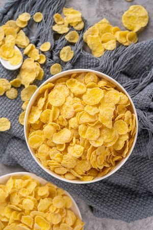 Corn flakes bowl sweets on gray cement background, top view flat lay layout design, fresh and...