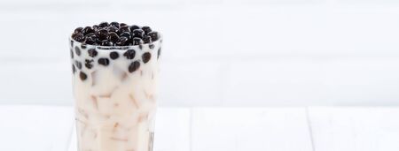 Bubble milk tea with tapioca pearl topping, famous Taiwanese drink on white wooden table background in drinking glass, close up, copy spaceの写真素材
