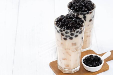 Bubble milk tea with tapioca pearl topping, famous Taiwanese drink on white wooden table background in drinking glass, close up, copy spaceの写真素材
