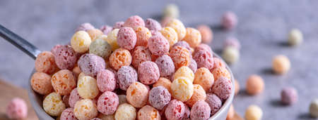 Colorful cereal corn balls mix, fruit flavor bowl sweets on gray cement background, close up, fresh, delicious and healthy breakfast, copy space design concept.の写真素材