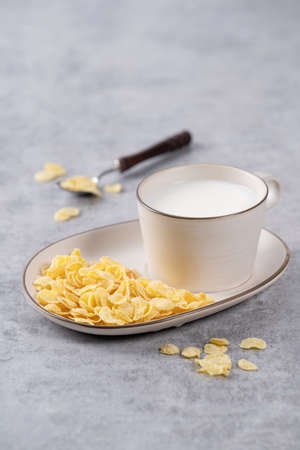 Corn flakes bowl sweeties with milk on gray cement background, close up, fresh and healthy breakbast design concept.の写真素材