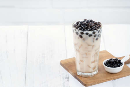 Bubble milk tea with tapioca pearl topping, famous Taiwanese drink on white wooden table background in drinking glass, close up, copy spaceの写真素材