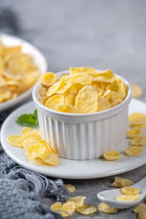 Corn flakes bowl sweeties with milk on gray cement background, close up, fresh and healthy breakfast design concept.の写真素材