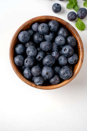 Blueberry fruit top view isolated on a white background, flat lay overhead layout with mint leaf,...