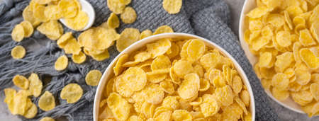 Corn flakes bowl sweets on gray cement background, top view flat lay layout design, fresh and...