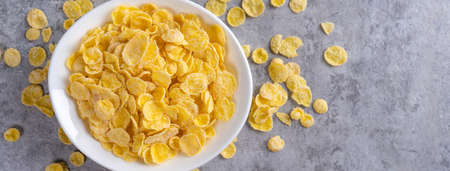 Corn flakes bowl sweets on gray cement background, top view flat lay layout design, fresh and...