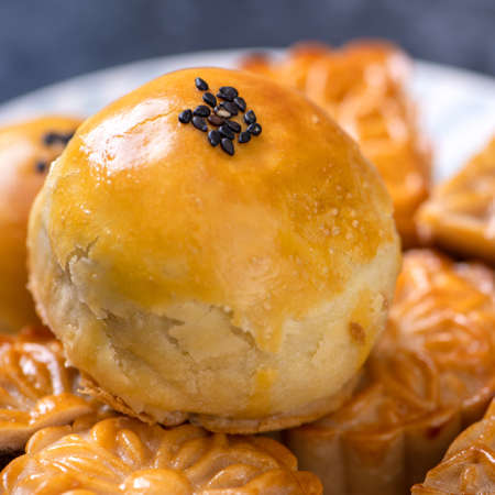 Tasty baked egg yolk pastry moon cake for Mid-Autumn Festival on black slate dark background....