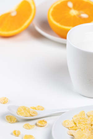 Corn flakes bowl sweeties with milk and orange on white background, close up, fresh and healthy breakfast design concept.の写真素材