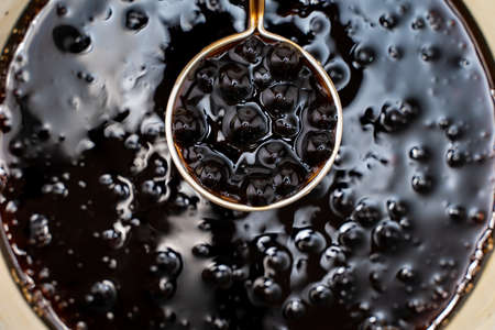 Cooking, boiling brown sugar flavor tapioca pearl balls, ingredient of bubble tea, preparing food and drink, close up, recipe cookbook steps design concept.の写真素材
