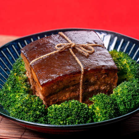 Dong Po Rou (Dongpo pork meat) in a beautiful blue plate with green broccoli vegetable, traditional...