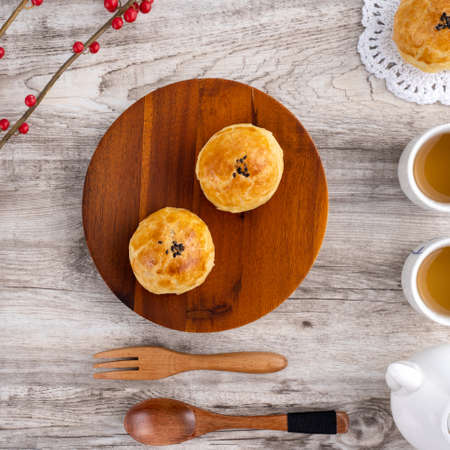 Moon cake yolk pastry, mooncake for Mid-Autumn Festival holiday, top view design concept on bright wooden table with copy space, flat lay, overhead shotの写真素材