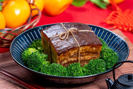 Dong Po Rou (Dongpo pork meat) in a beautiful blue plate with green broccoli vegetable, traditional...