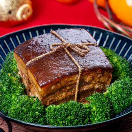 Dong Po Rou (Dongpo pork meat) in a beautiful blue plate with green broccoli vegetable, traditional...