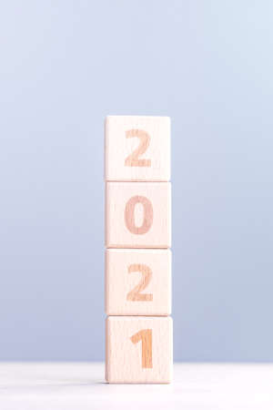 2021 New Year abstract design concept-Number wood block cubes isolated on wooden table and light...