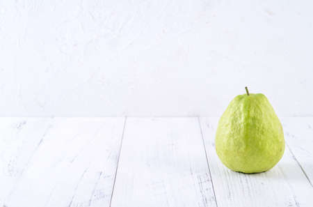Delicious beautiful Guava set with fresh leaves isolated on bright white wooden table background, close up.の写真素材
