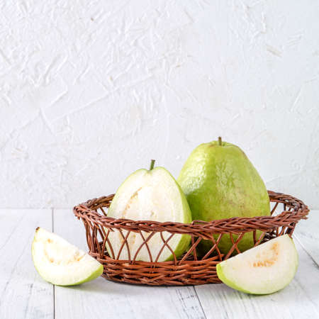 Delicious beautiful Guava set with fresh leaves isolated on bright white wooden table background, close up.の写真素材