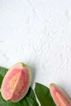 Top view, flat lay of delicious beautiful Red guava with fresh green leaves isolated on white table background, studio overhead table shot with copy space.の写真素材