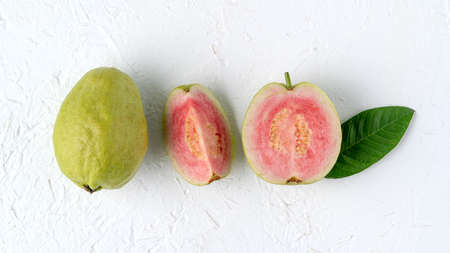 Top view, flat lay of delicious beautiful Red guava with fresh green leaves isolated on white table background, studio overhead table shot with copy space.の写真素材
