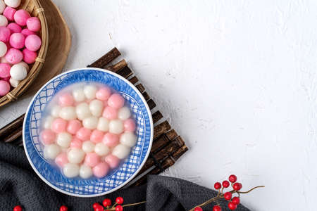 Top view of red and white tangyuan (tang yuan, glutinous rice dumpling balls) in blue bowl on white background for Winter solstice festival food.の写真素材