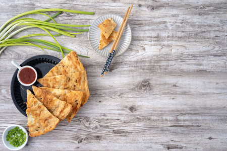 Taiwanese food-delicious flaky scallion pie pancakes on bright wooden table background, traditional snack in Taiwan, top view.の写真素材