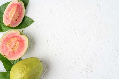 Top view, flat lay of delicious beautiful Red guava with fresh green leaves isolated on white table background, studio overhead table shot with copy space.の写真素材