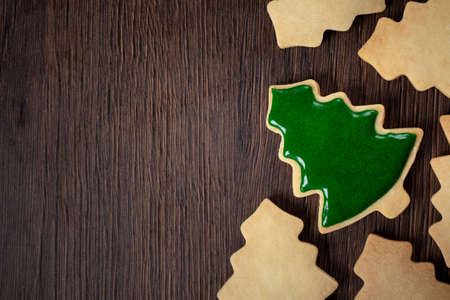 Top view of decorated green plain flavor gingerbread Christmas tree cookie on wooden table...