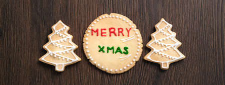 Top view of decorated green plain flavor gingerbread Christmas tree cookie on wooden table...