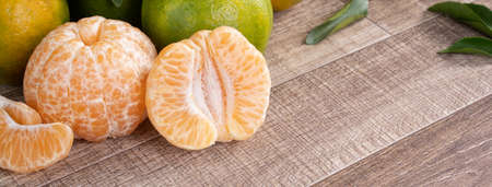 Fresh ripe tangerine mandarin orange in a box with fresh leaves on wooden table background harvest concept.の写真素材