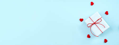 Valentine's Day greeting handmade gift design concept-Top view of wrapped gift box on bright blue background, flat lay overhead layout.の写真素材