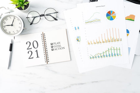 Top view of office table desk 2021 Goal work concept with keyboard, notebook, pencil, eyeglasses and...