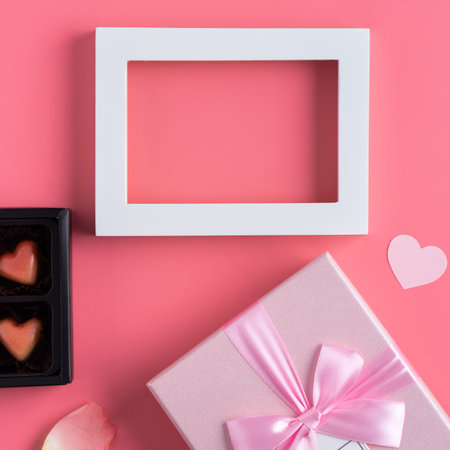 Valentine's Day design concept background with pink petals and gift box on pink backgroundの写真素材