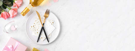White plate with gift and pink rose flower on marble white table background for Valentine's Day...