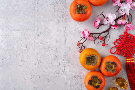 Fresh persimmons on gray table background for Chinese new year fruit designの写真素材