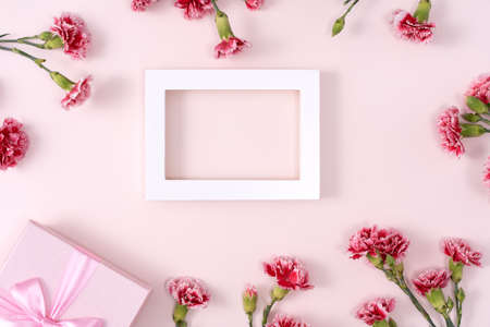 Concept of Mother's day holiday greeting background design with carnations bouquet on pink...