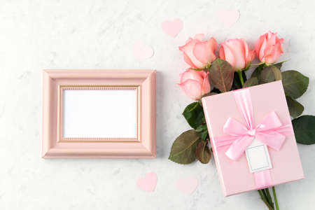 Giftbox and pink rose flower on marble white table background for Valentine's Day holiday greeting...