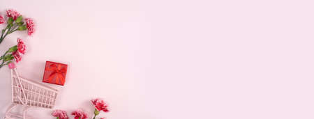 Concept of Mother's day holiday greeting design with carnation bouquet and gift on pink backgroundの写真素材