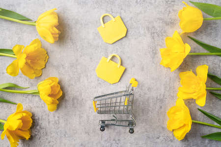 Concept of Mother's day holiday gift shopping greeting design with yellow tulip flower bouquet on...