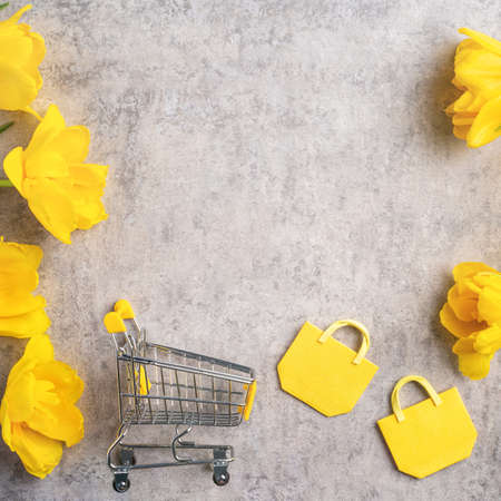 Concept of Mother's day holiday gift shopping greeting design with yellow tulip flower bouquet on gray backgroundの写真素材