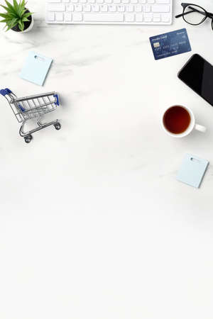 Top view of online shopping concept with credit card, smart phone and computer isolated on office marble white table background.の写真素材