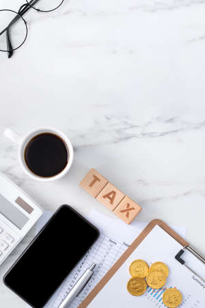 Top view of reading the overview and calculating, paying tax with smart phone from internet.の写真素材