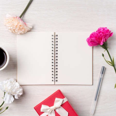 Design concpet of Mother's Day greeting with carnation flower, holiday gift idea and notebook diary...