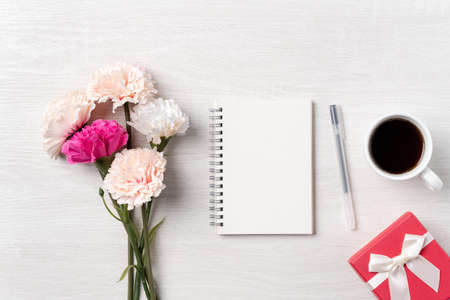 Design concpet of Mother's Day greeting with carnation flower, holiday gift idea and notebook diary on mother's desk background.の写真素材